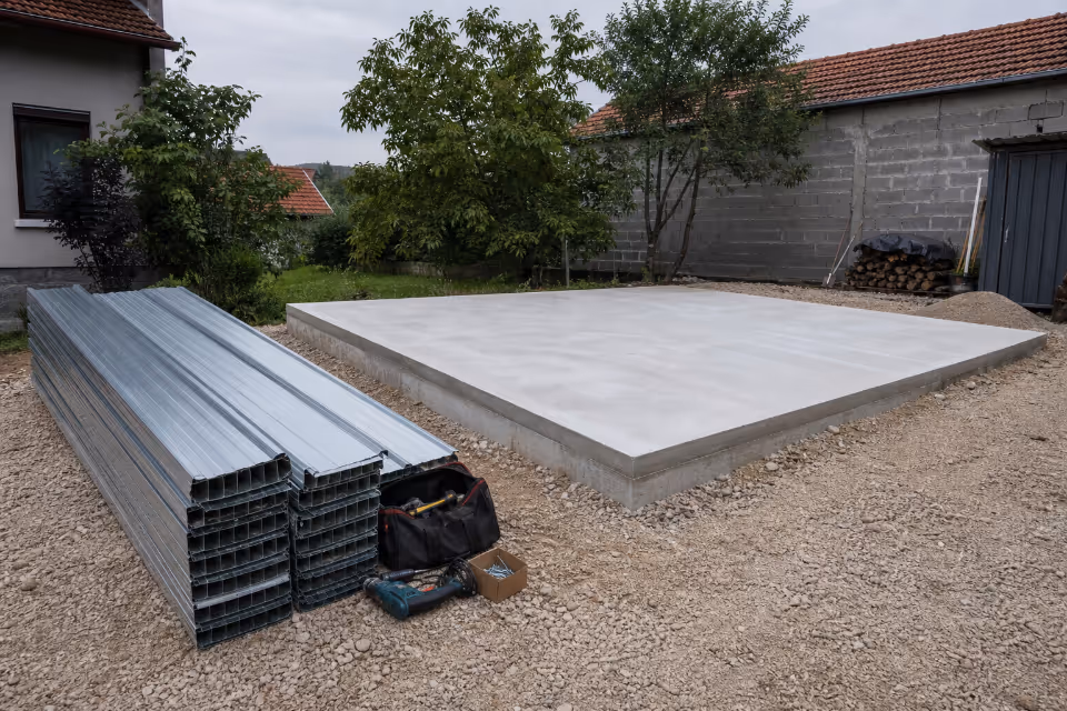 Betonska ploča za terasu u dvorištu, uz slojeve valovitog lima i alat za montažu.