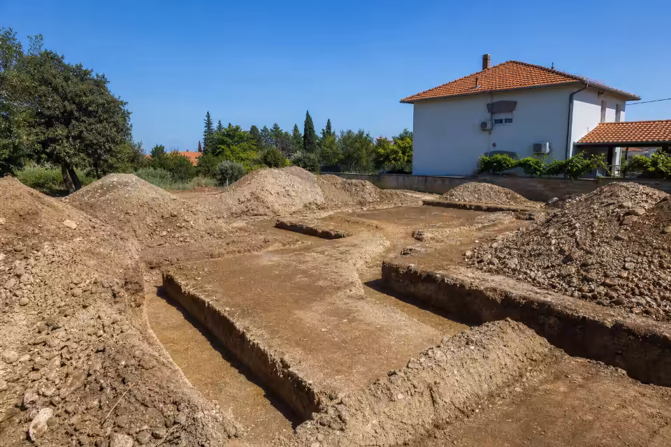Iskopani temelji kuće na gradilištu sa nasutim zemljanim nasipima, prikaz faze pripreme terena za gradnju