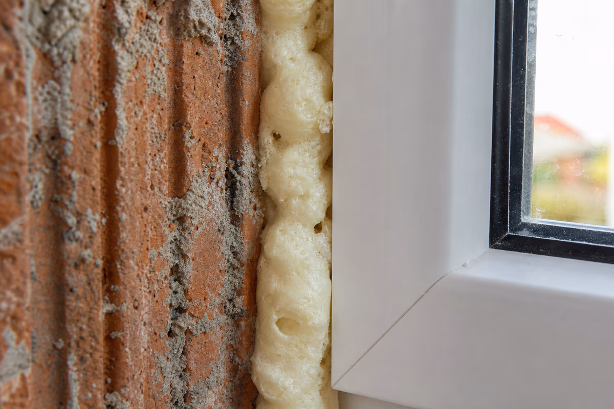 Detalj presjeka šupljine oko prozorskog okvira gdje se pjena širi i lijepi za podlogu.
