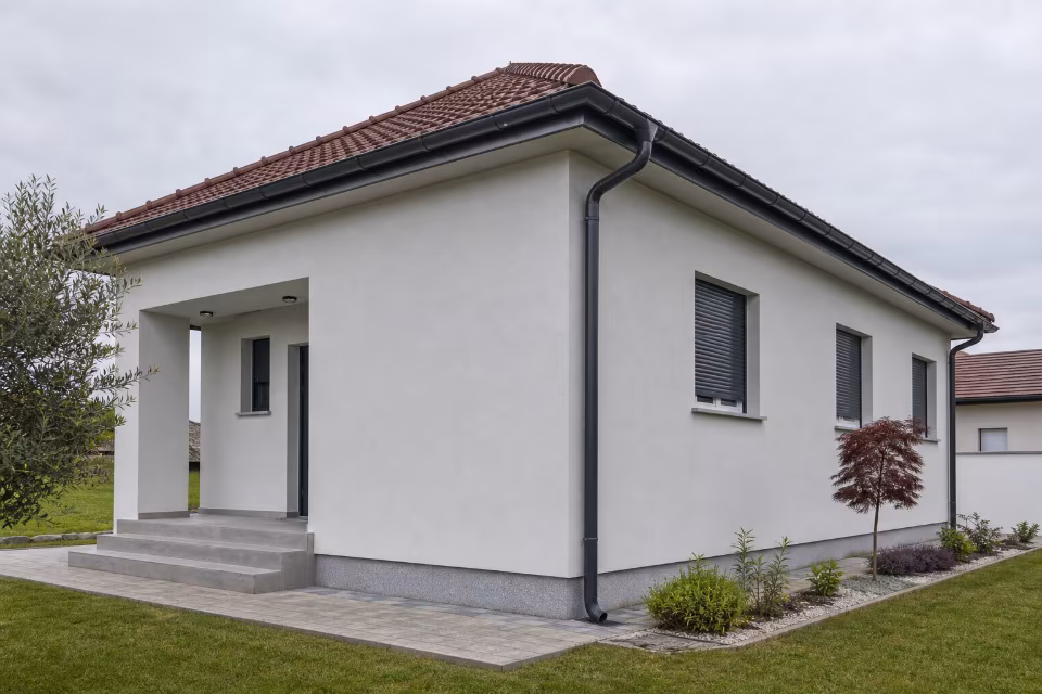 Širi prikaz kuće s ugrađenim sistemom oluka i vertikalnih cijevi za odvodnju kišnice s krova.