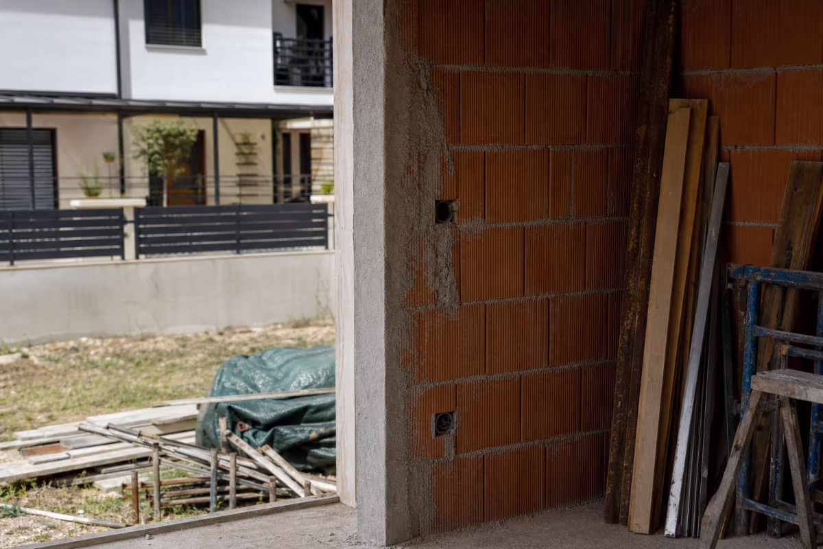 Osoba pregledava ugovor i fotografije oštećenih radova na stolnom računalu — materijali i alat