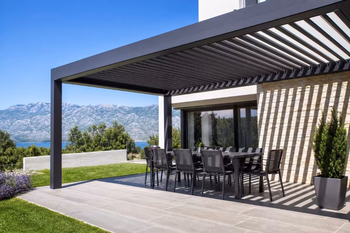 Sodobna aluminijasta pergola z bioklimatskimi lamelami nad urejeno teraso