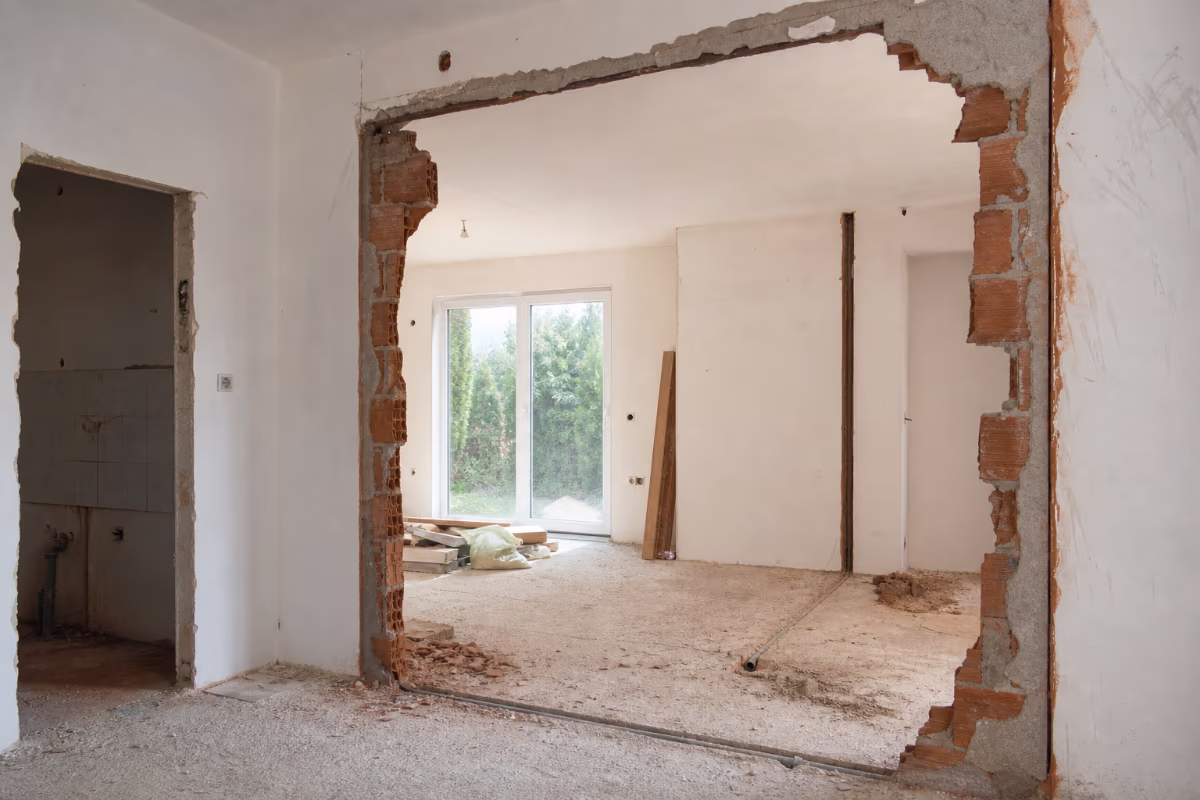 Građevinski inženjer ili majstor poređuje dokumentaciju i ponude na gradilištu — materijali i alat