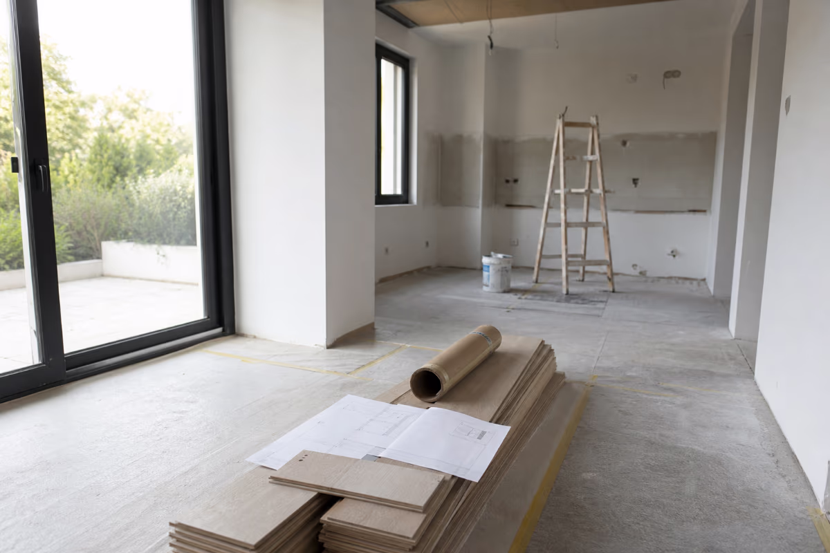 Majstor i vlasnik kuće pregledavaju planove i zapisnik na gradilištu — materijali i alat