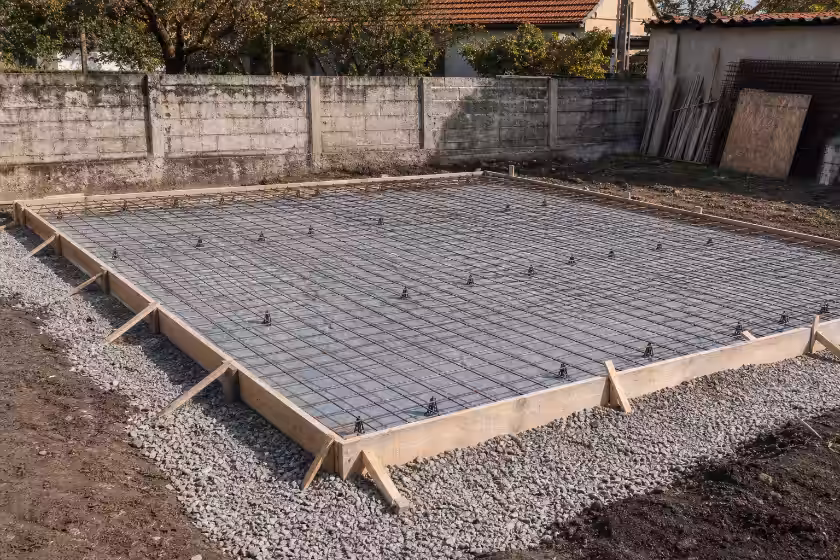 Priprema temelja za izgradnju: armaturna mreža unutar drvene kalupnice na sloju šljunka.