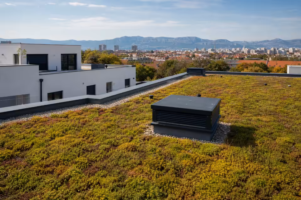 Zeleni krov s vegetacijom i ventilacijskim uređajem, dio moderne ekološke gradnje u urbanom okruženju