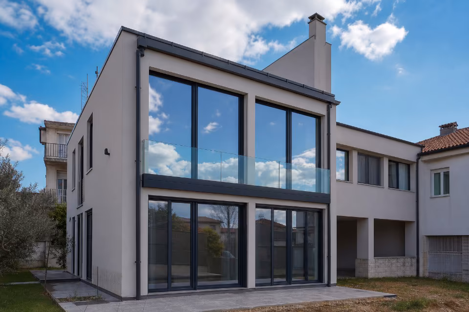 Moderna kuća s velikim staklenim površinama i balkonom, primjer kvalitetne ugradnje stakla za energetsku učinkovitost i