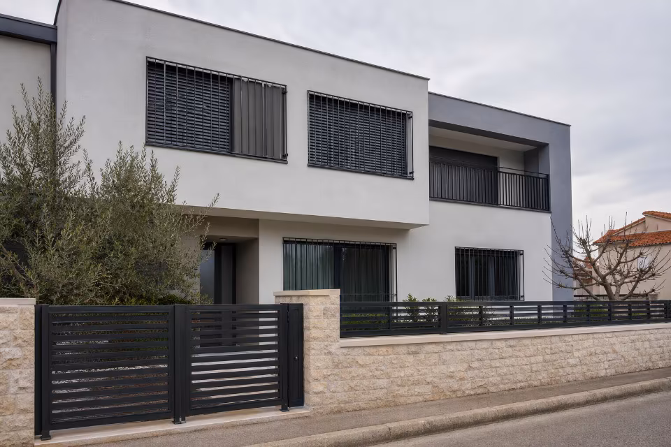 Fasada moderne zgrade s prozorima opremljenim sigurnosnim rešetkama i ojačanim okvirima