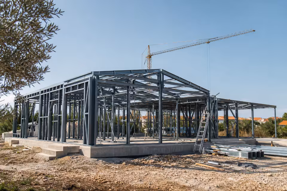 Čelična konstrukcija zgrade u izgradnji s dizalicom na pozadini, prikaz sigurne statičke konstrukcije kao temelja cijelo