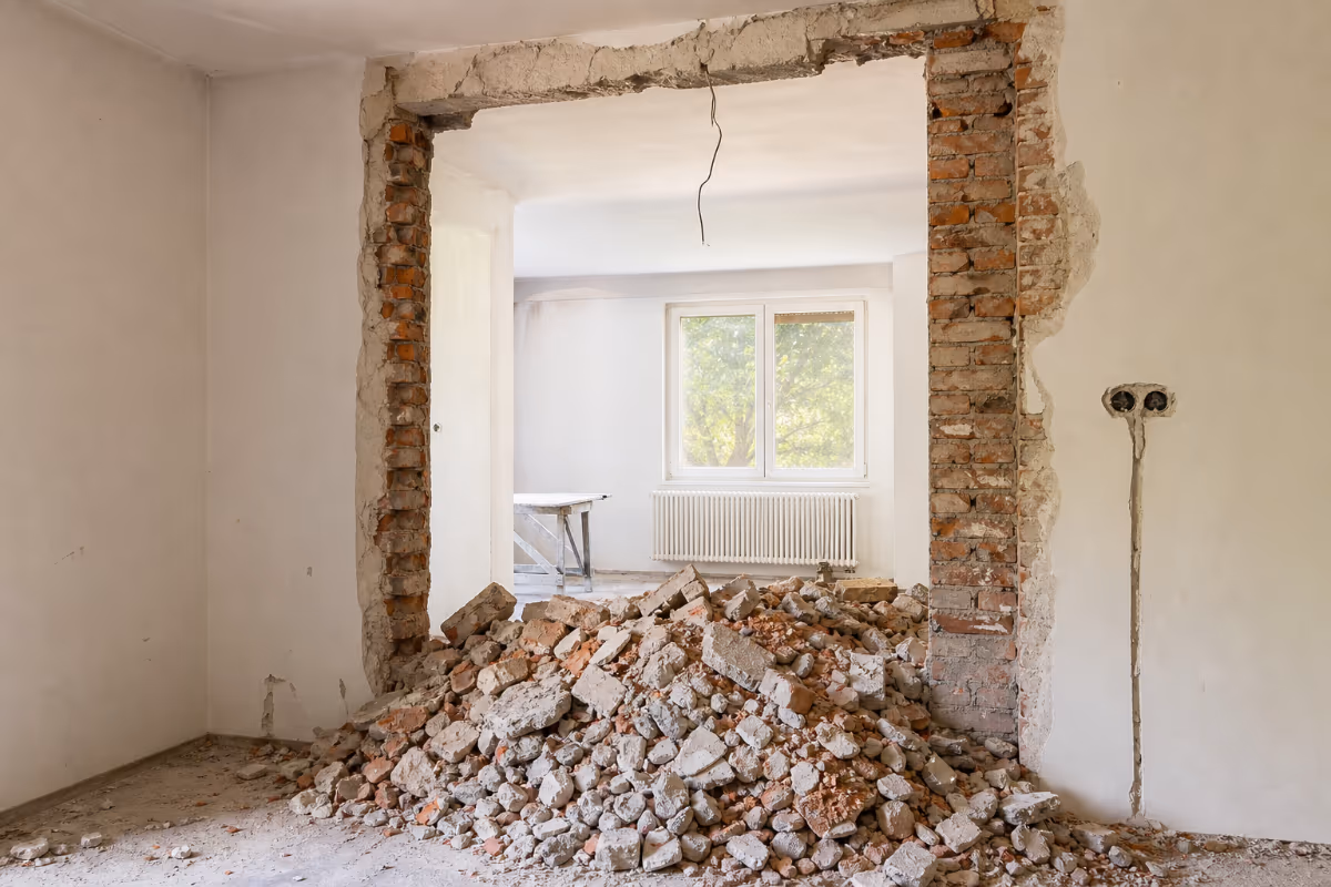 Radnik ruši pregradni zid čekićem u stanu tokom adaptacije — detalj izvedbe