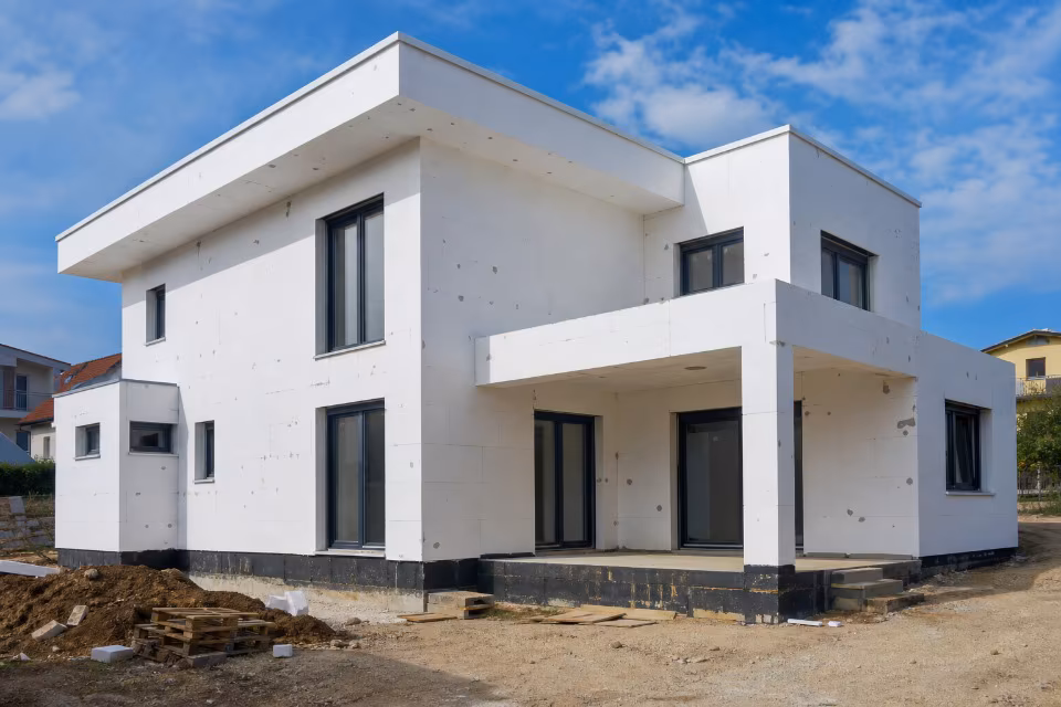 Bele EPS ploče na fasadi moderne porodične kuće pri dnevnom svetlu