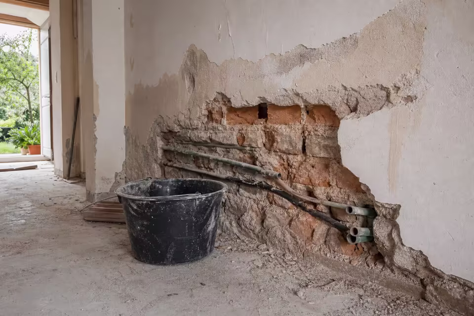 Arhitekt ili majstor s kalkulatorom i planovima na gradilištu — širi prikaz